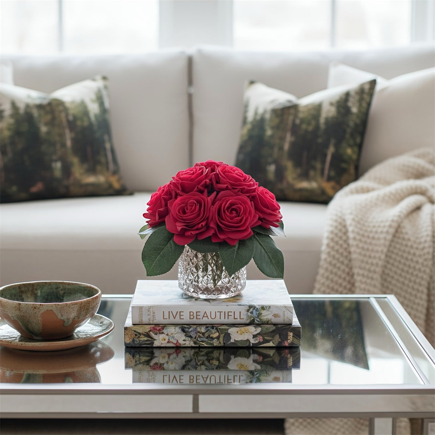 Red roses in a crystal vase on books with a cozy living room background