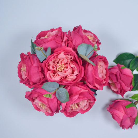 Bouquet of pink flowers with green leaves on a light gray background