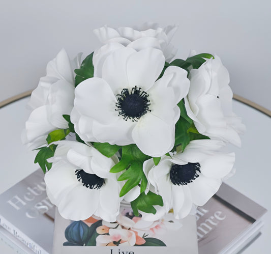 Bouquet of white flowers with green leaves on a magazine