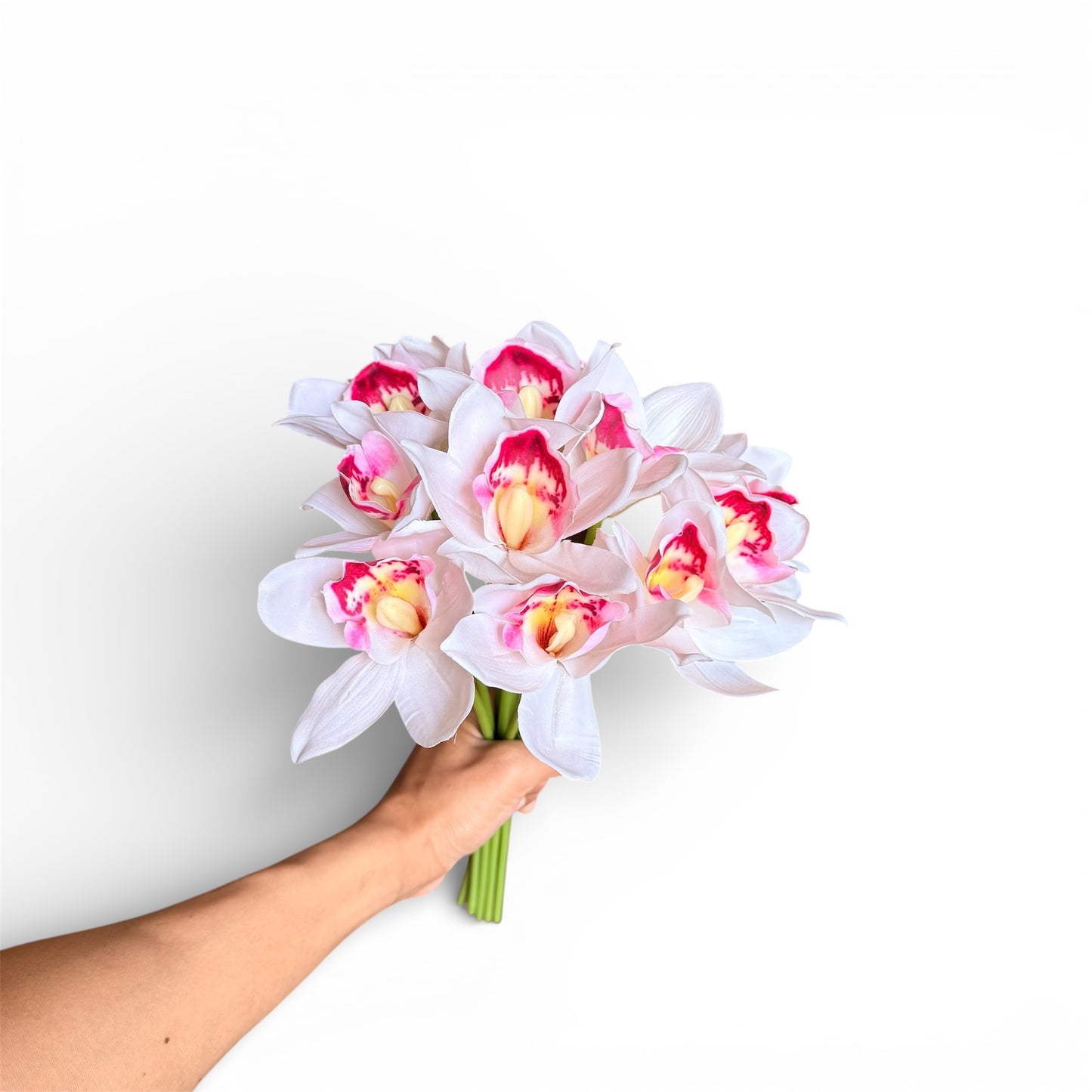 Hand holding a bouquet of pink and white flowers against a white background