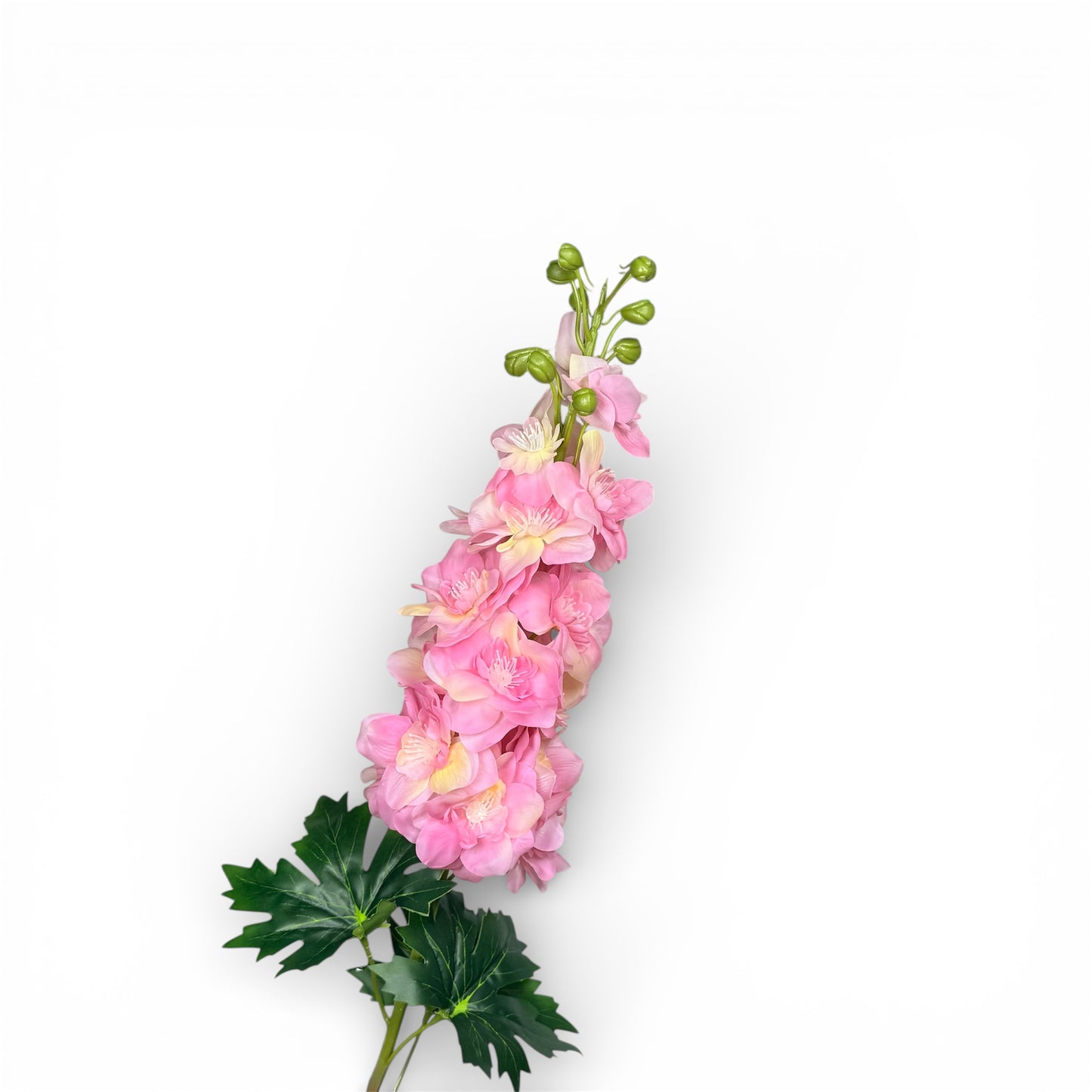 Artificial pink flower arrangement with green leaves on a white background