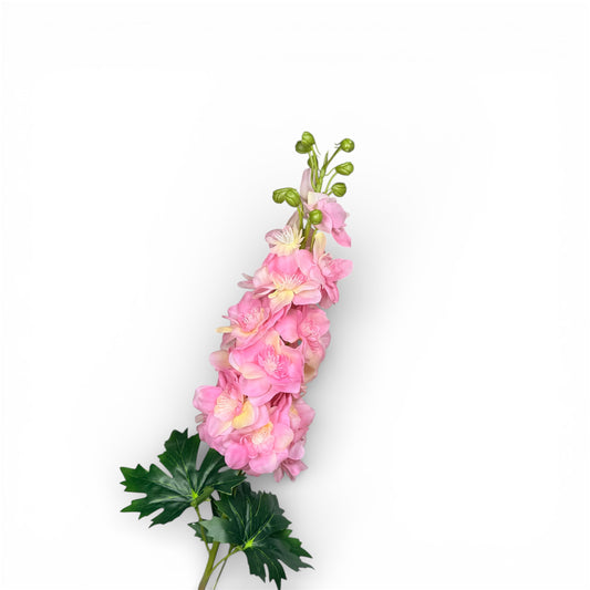 Artificial pink flower arrangement with green leaves on a white background