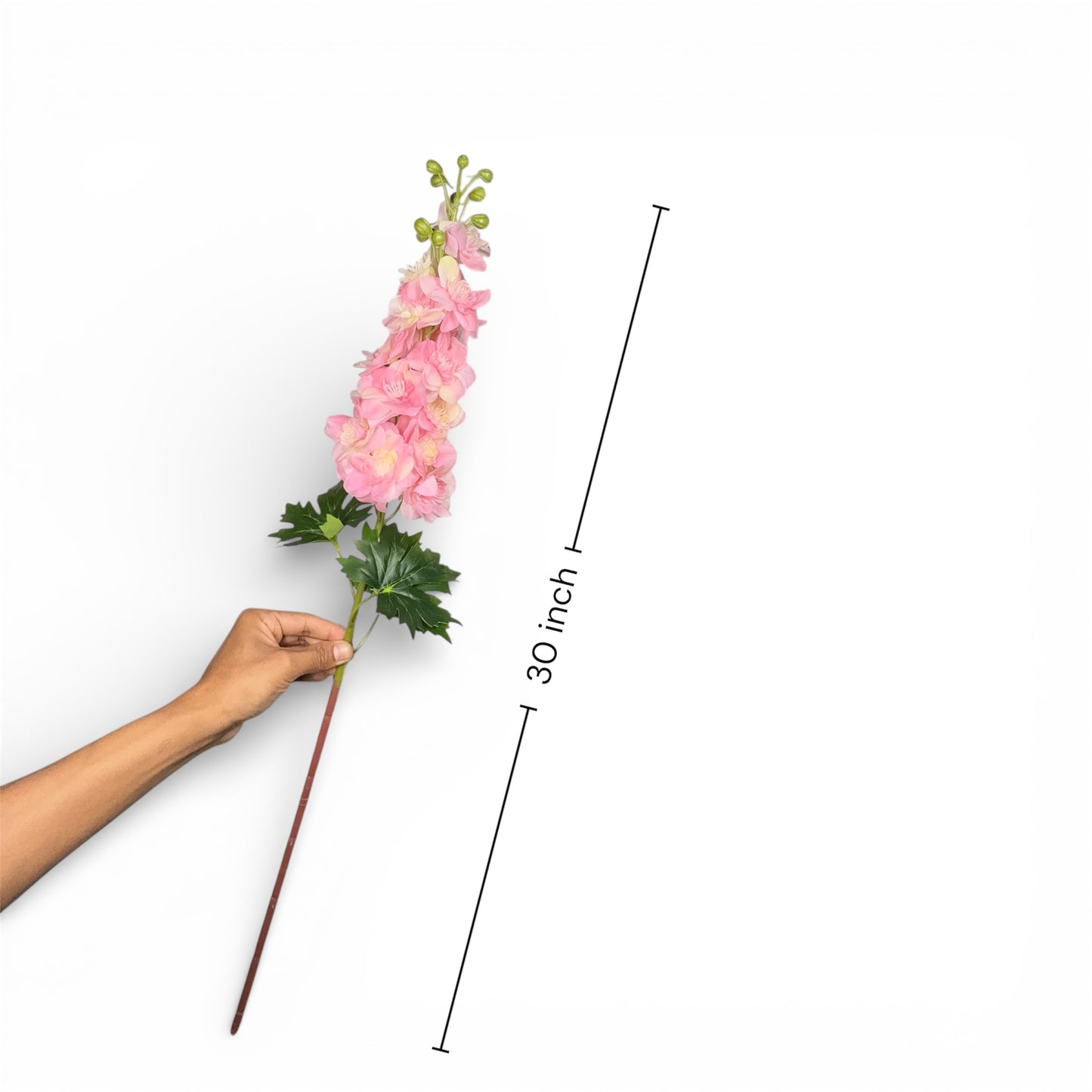 Hand holding a pink artificial flower stem with measurement label on a white background