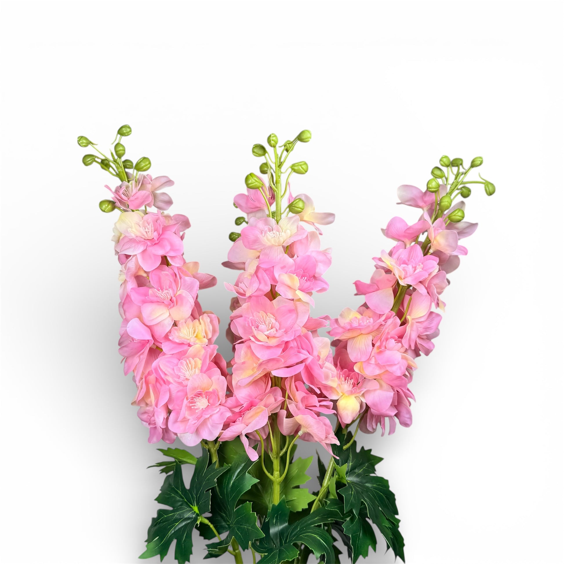 Pink artificial flowers arranged to spell out the letter 'W' on a white background