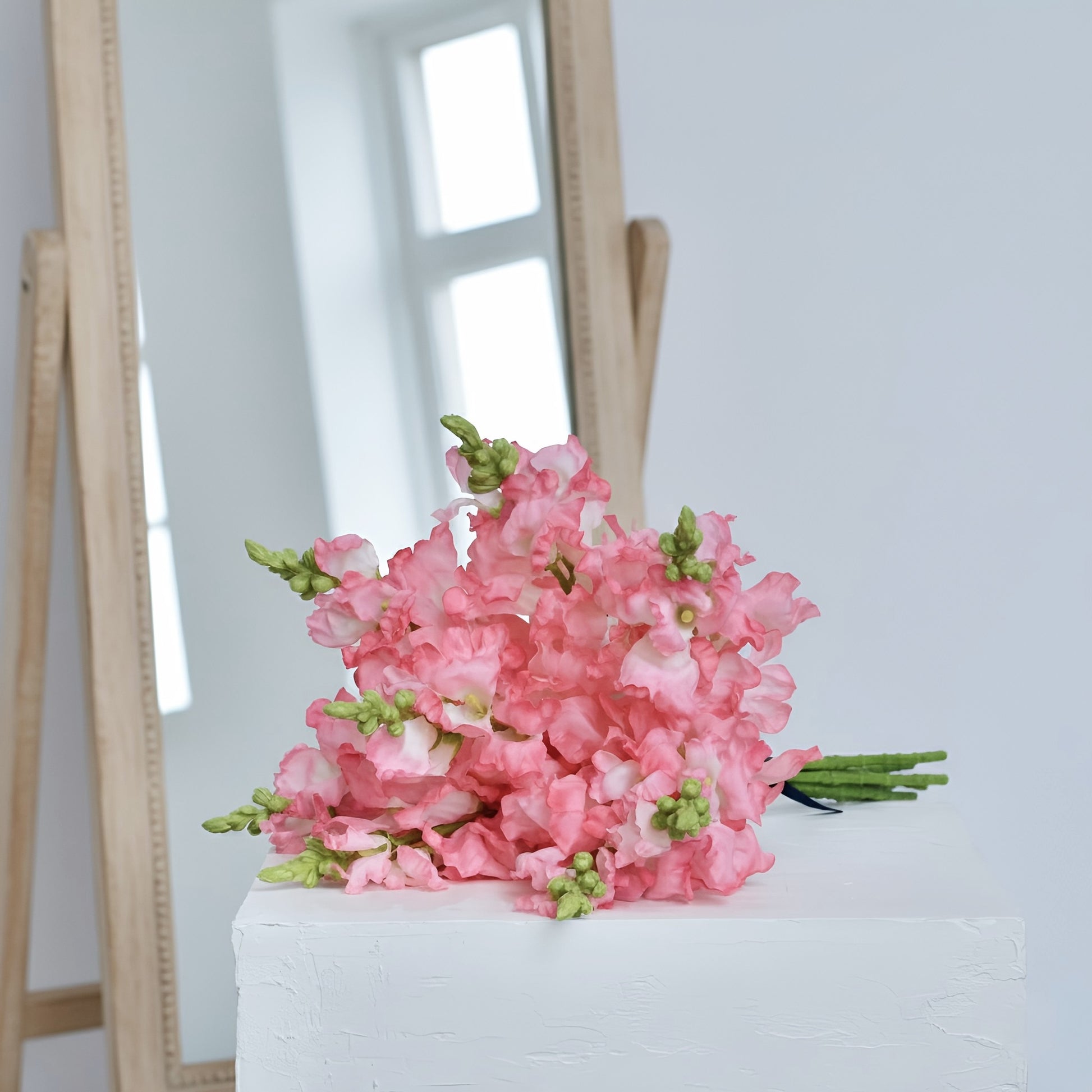 Bouquet of pink flowers on a white surface with a blurred background