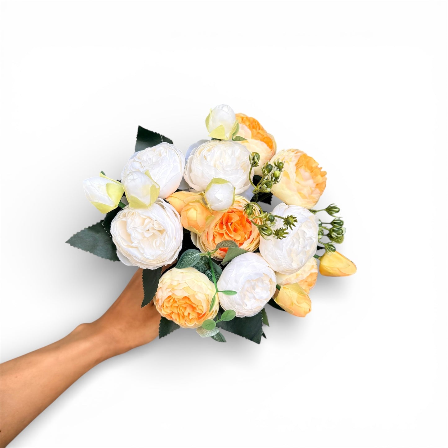 Bouquet of white and yellow flowers held by a hand on a white background