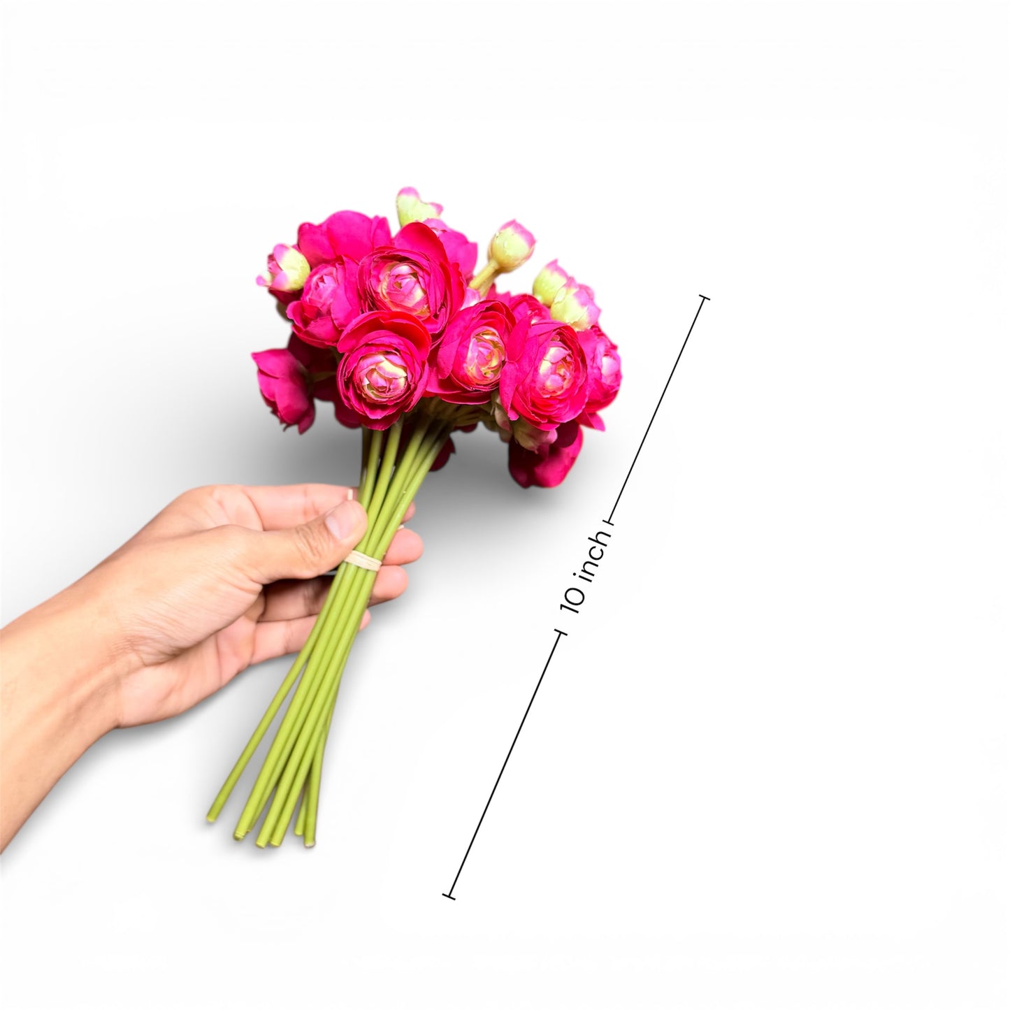Hand holding a bouquet of pink flowers with a measurement line indicating 10 inches on a white background