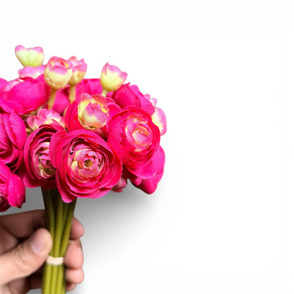 Bouquet of pink flowers held by a hand against a white background