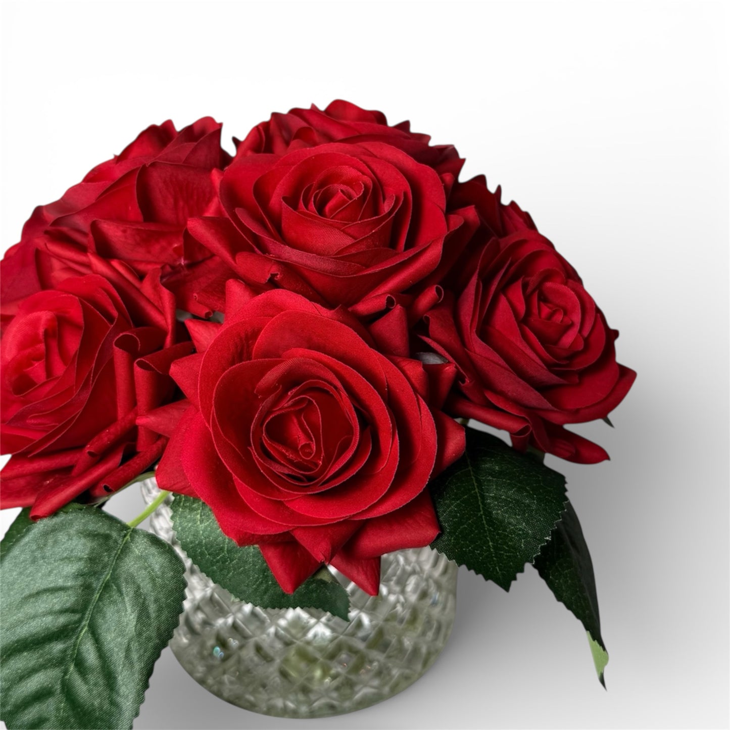 Bouquet of red roses in a clear vase on a white background