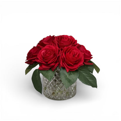 Bouquet of red roses in a decorative glass vase on a white background
